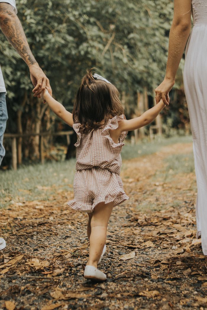 Crafting Captivating Headlines: Your awesome post title goes here Child holding hands with parents on a peaceful nature walk.